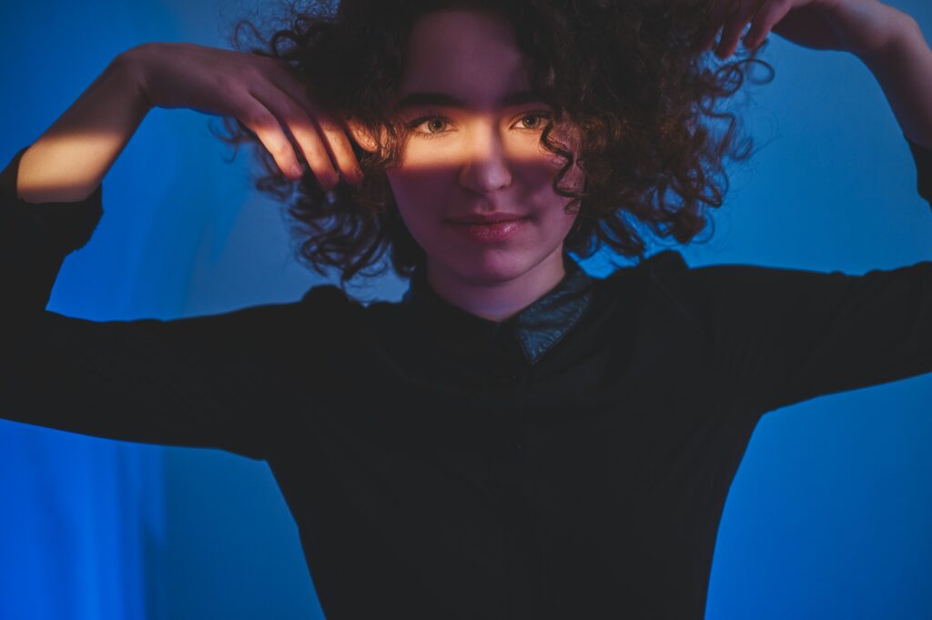 Curly woman with stripe of light on the face