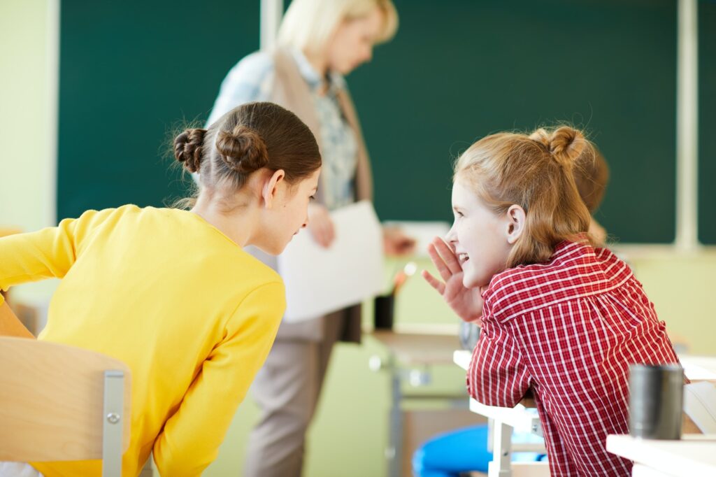 Jolly girls gossiping at class