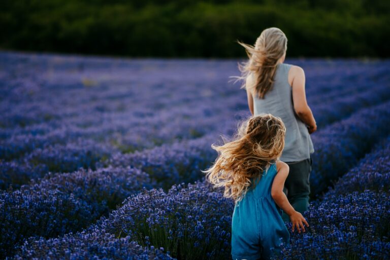Women with little girl. Lavender field. Girl in blue dress.
